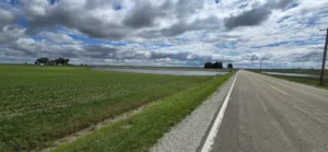 Field alongside road with large area of standing water
